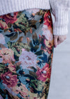 Close up on warm floral on a sage background of a maxi skirt with a back zipper and silky material. 