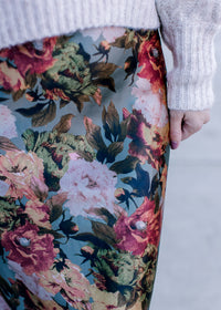 Close up on warm floral on a sage background of a maxi skirt with a back zipper and silky material. 