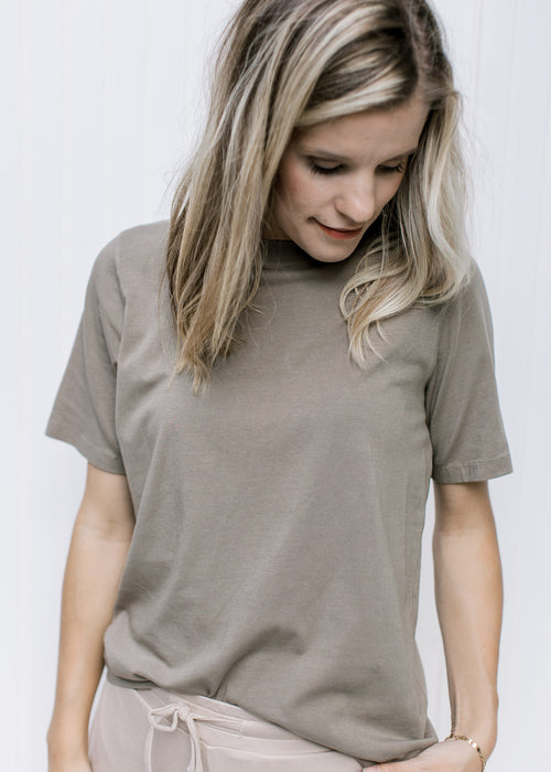 Model wearing a classic grey tee with a round neck, short sleeves and a Pima cotton material. 