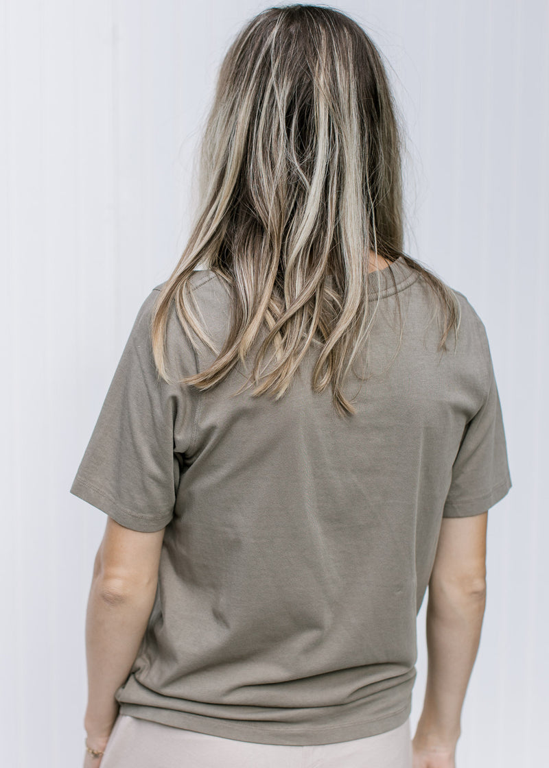 Back view of Model wearing a grey tee with a round neck, short sleeves and a Pima cotton material.