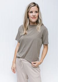 Model wearing tan bottoms and an ultra soft grey tee with a round neck and short sleeves. 