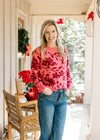 Model wearing jeans and a rose sweater with burgundy floral, ribbed material and long sleeves. 