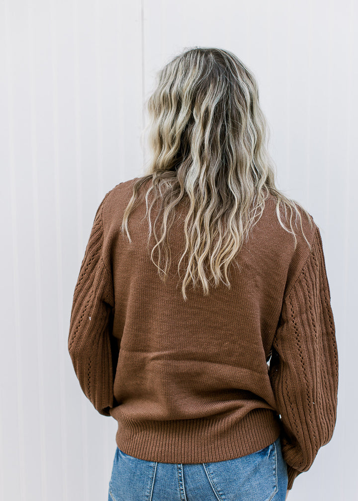 Back view of Model wearing a long sleeve mocha brown sweater with a diamond knit pattern. 