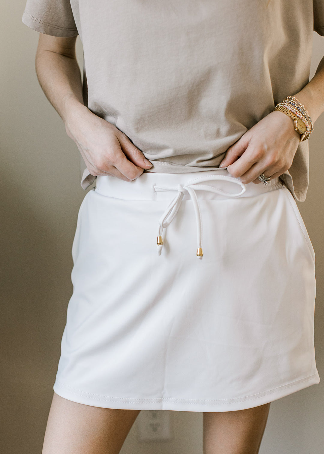 Close up of adjustable tie and elastic waistband on a white skort with built in shorts. 