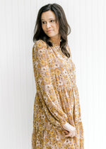 Model wearing a long sleeve polyester dress with a chestnut color and a natural floral pattern. 