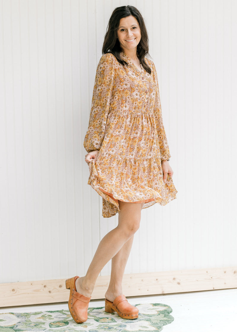 Model wearing a fully lined, above the knee dress with a chestnut color with floral design. 