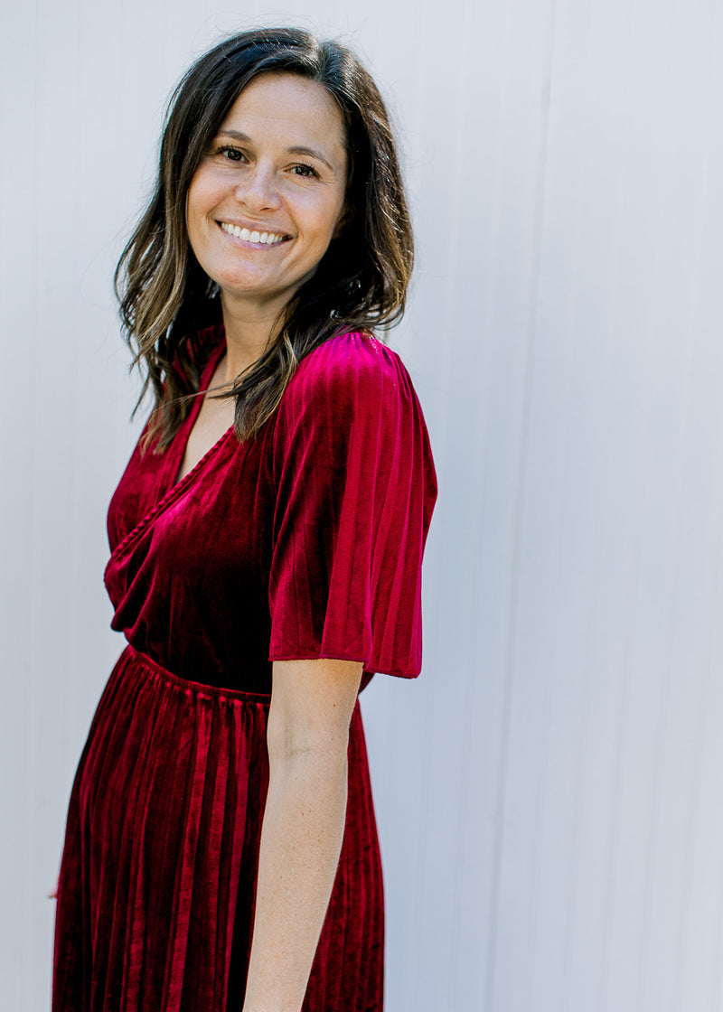 Close up of short sleeves and faux wrap bodice on a velvet wine colored midi with a v-neck. 