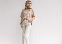 Model wearing sand colored pants comprised of cotton with a cropped fit and wide legs. 