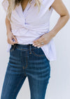 Close up of the elastic band on a medium wash, high waisted, skinny jeans. 