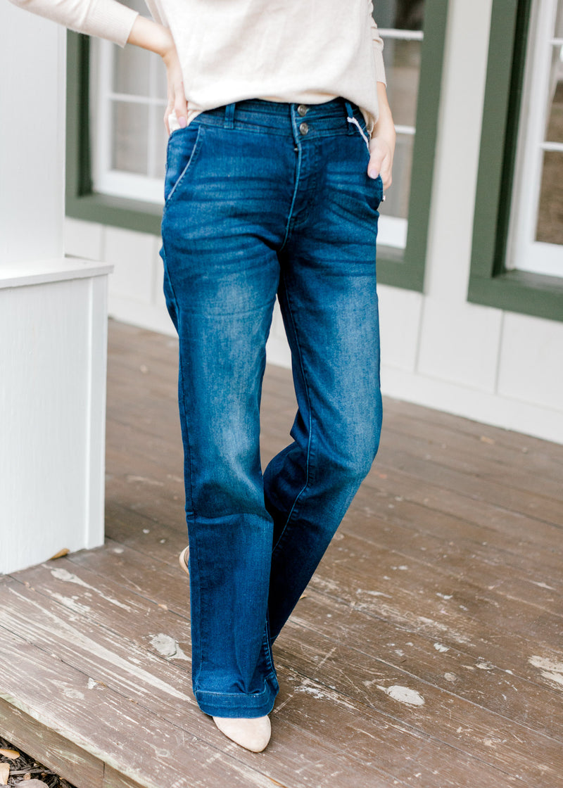 Model wearing wide leg, dark wash, jeans with booties. 