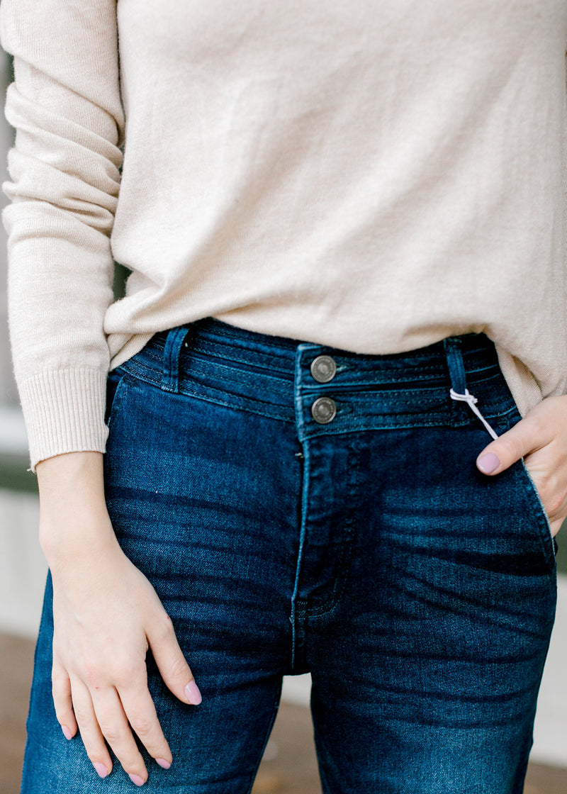 Close up view of Model wearing wide leg, dark wash, jeans. 