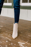 Close up view of fray hem on skinny jeans. 