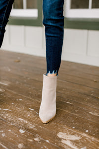 Close up view of fray hem on skinny jeans. 