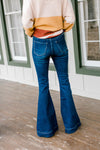 Back view of Model wearing flare, hi-rise jeans. 
