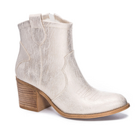 Gold tone bootie on white background.
