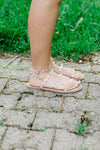 Side view of A pair of clear lucite sandals with silver stud on model.
