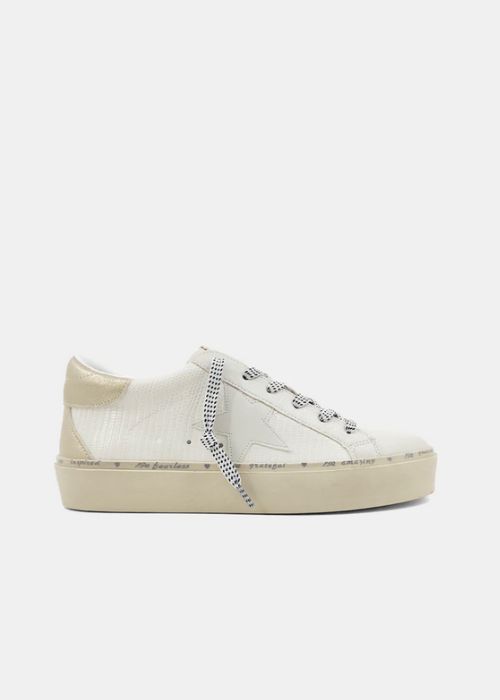 Bone colored sneakers with a star on the side and a round toe. 