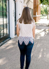 BAck view of Brunette model wearing cream colored cut lace top.