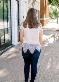 BAck view of Brunette model wearing cream colored cut lace top.