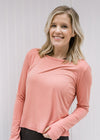 Blonde model wearing an apricot color athletic top.