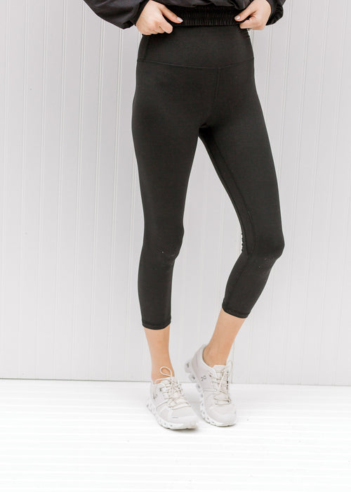 Model wearing black capri yoga pants. 