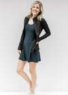 Blonde model wearing a navy romper dress with a black jacket.