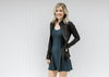 Blonde model wearing a navy romper workout dress with a black zip up jacket.