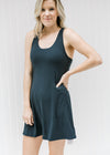 Blonde model wearing a navy romper workout dress. 