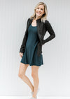 Blonde model wearing a navy romper workout dress with a jacket and tennis shoes.