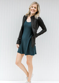 Blonde model wearing a navy romper workout dress with a jacket and tennis shoes.