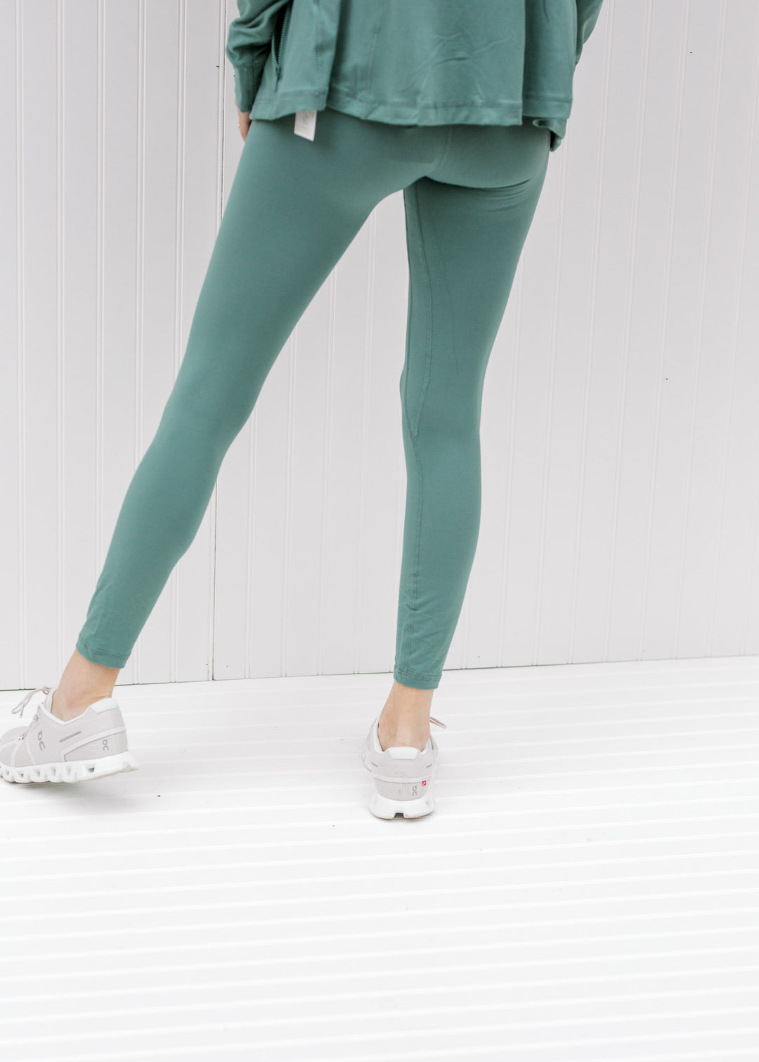 Back view of model wearing teal leggings.