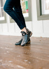 Black bootie with low stacked heel and decorative straps. 
