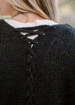 Close up view of criss cross detail on back of cardigan. 