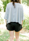 Back view of Brunette model wearing black elastic waist tulip shorts.