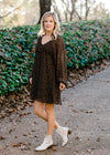 Blonde model wearing black dress with ditsy pink floral pattern. 