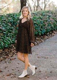 Blonde model wearing black dress with ditsy pink floral pattern. 
