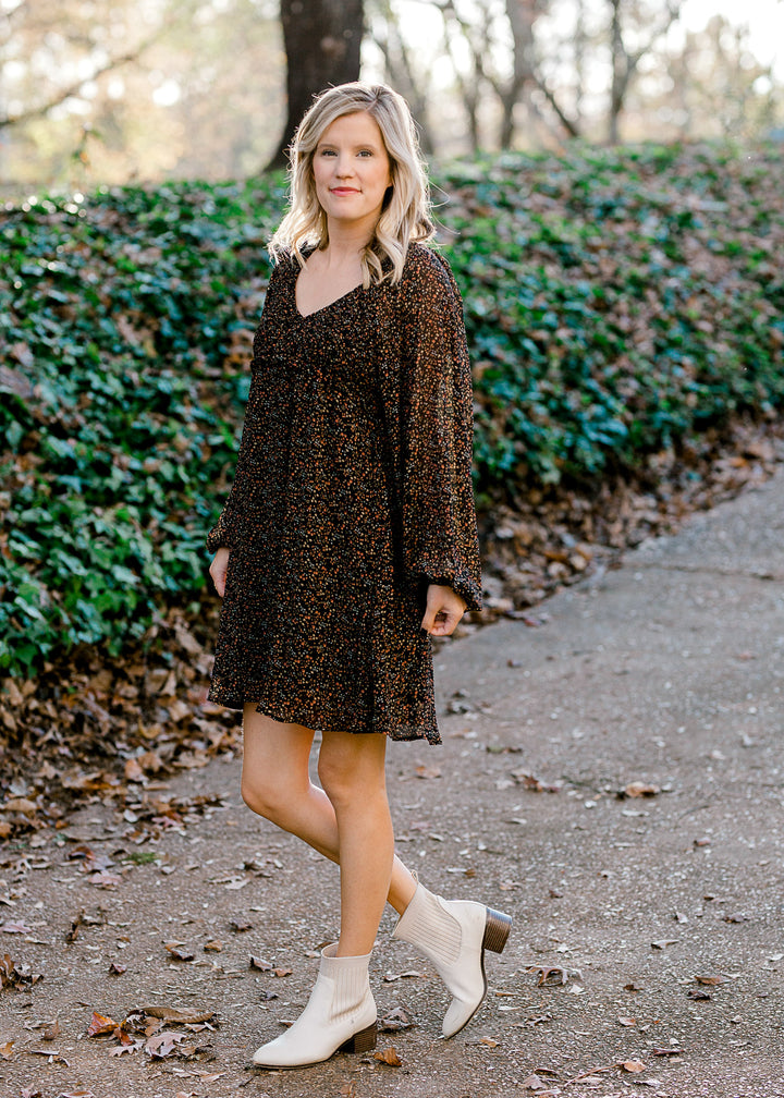 Blonde model wearing black dress with ditsy pink floral pattern. 