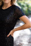 Detail of Blonde model wearing black sequin dress.