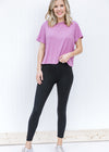 Blonde model wearing black v-waist leggings and pink top.