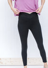 Waist detail of Blonde model wearing black v-waist leggings.