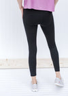 Back view of Blonde model wearing black v-waist leggings.