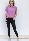 Blonde model wearing black v-waist leggings and sneakers.