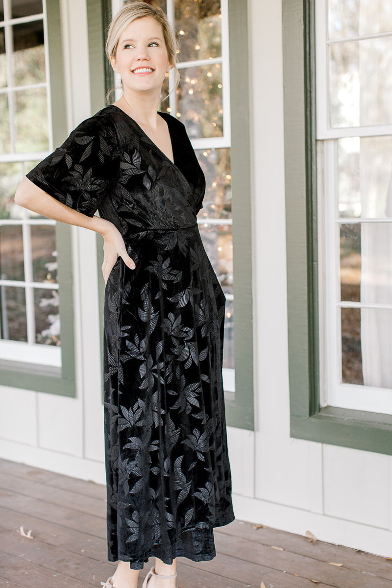 Blonde mode wearing floral tone on tone black velvet dress.