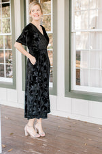 Blonde mode wearing floral tone on tone black velvet dress and heels.