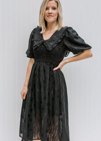 Blonde model wearing a black vintage midi dress. 