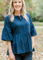 Blonde model wearing navy checked button up top.