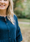 Close up of Blonde model wearing navy checked button up top.