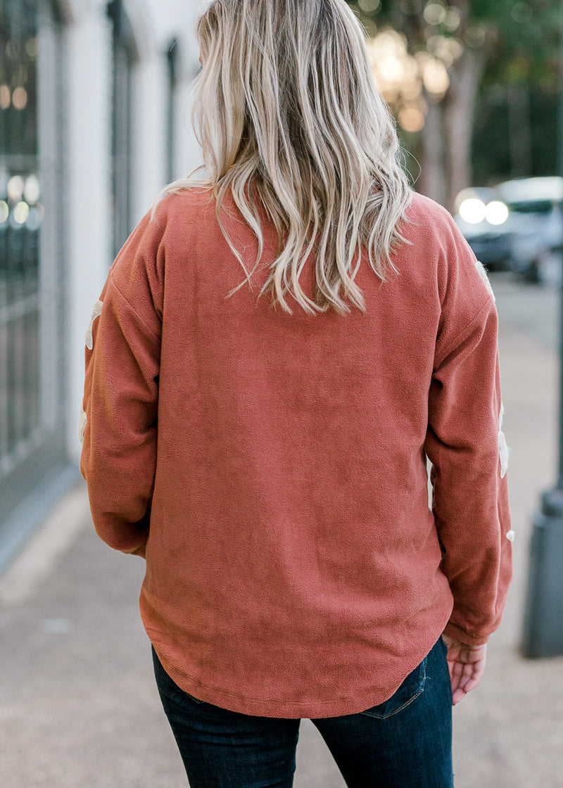 Blonde model wearing mauve colored sweater.