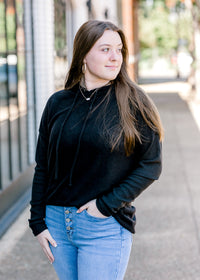 Brunette model wearing black hoodie. 