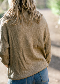 Back view of Blonde model wearing olive sweater. 